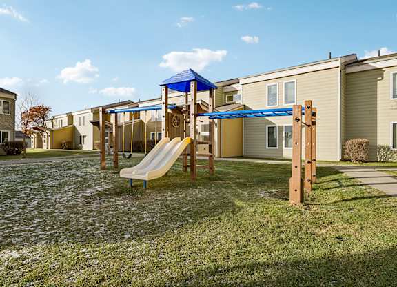 A playground with a slide and a wooden structure.