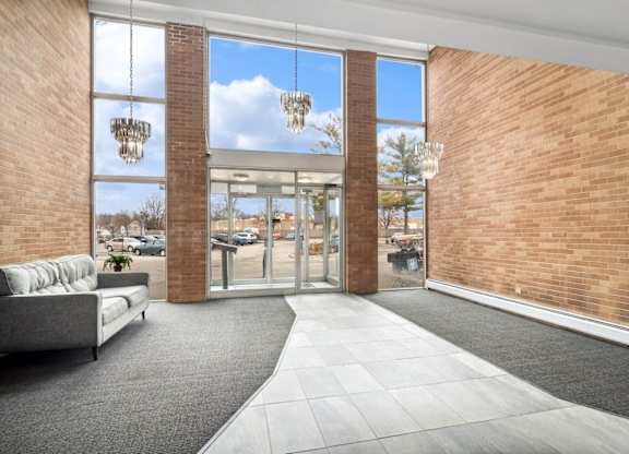 the lobby of a building with a couch and chandeliers