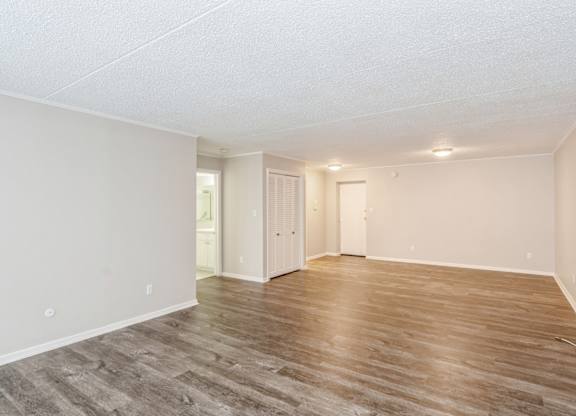 A room with wooden flooring and white walls.