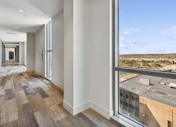 a long hallway with large windows and a view of a city at The Rowe, Michigan