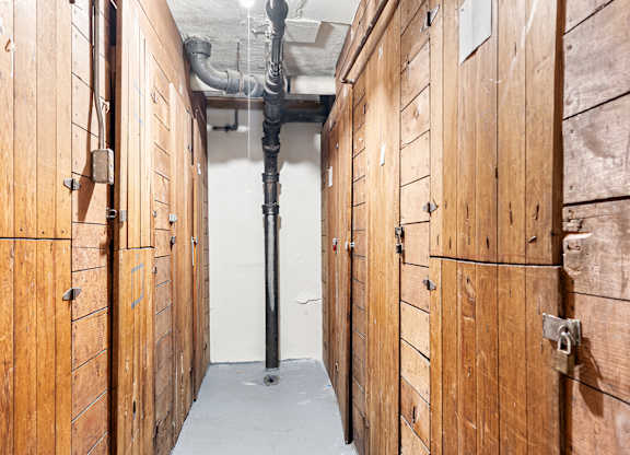 A long hallway with wood paneling and pipes on the ceiling.