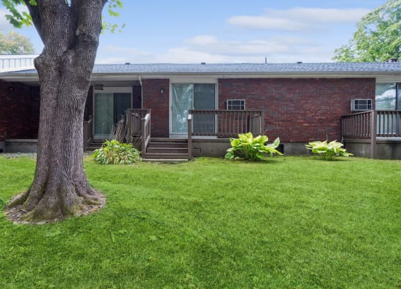 a view of a house with a yard and a tree