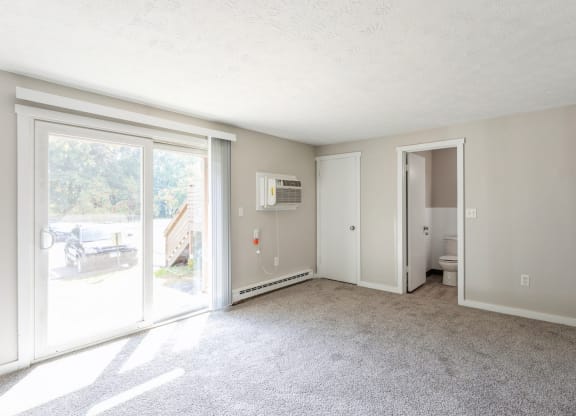 an empty living room with sliding glass doors to a patio at Stonebridge, Ellington, CT, 06029
