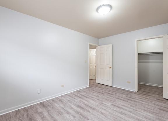 A room with a white door and a grey floor.