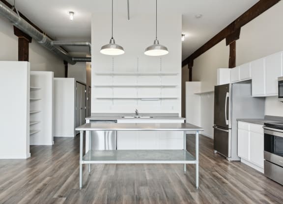a kitchen with white cabinets and stainless steel appliancesat Gaar Scott Historic Lofts, Minneapolis