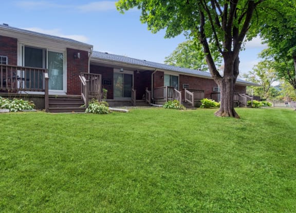 a view of the front of a house with a lawn and a tree