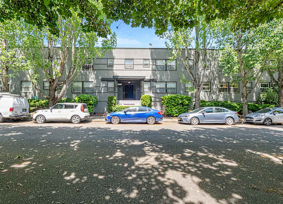A parking lot with cars and a building in the background.