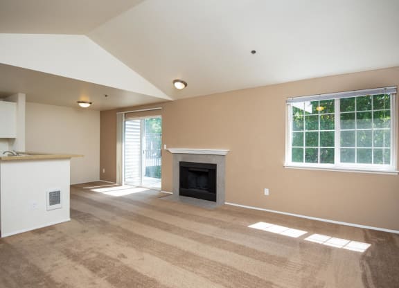 an empty living room with a fireplace and a kitchen at Murrayhill Park, Beaverton Oregon