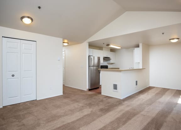 the living room and kitchen of an empty apartment with a stainless steel refrigerator at Murrayhill Park, Beaverton