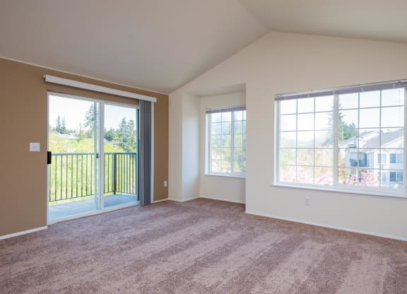 an empty living room with large windows and carpeting at Murrayhill Park, Oregon