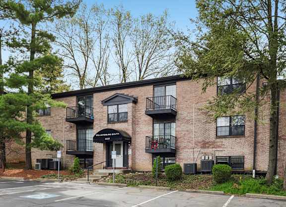 A brick building with a black awning and balconies.