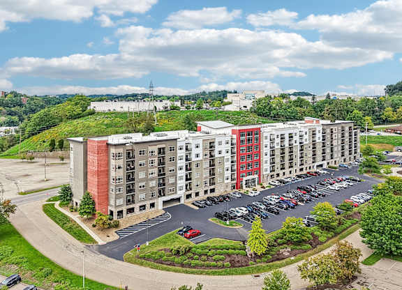 A large apartment complex with a parking lot in front.