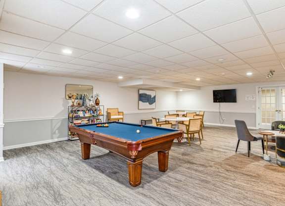A room with a pool table and a TV.