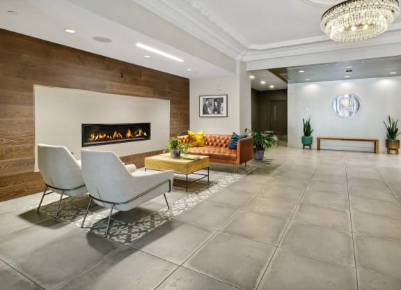 a living room with a couch and chairs in front of a fireplace at The Rowe, Grand Rapids, 49503