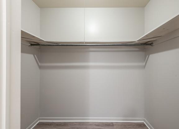 A white closet with a shelf and a hanging rod.