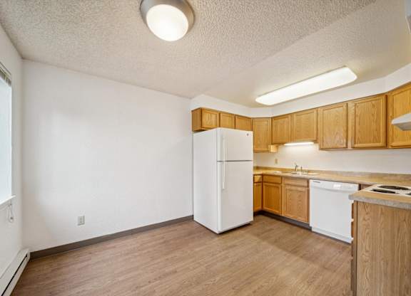 A kitchen with wooden cabinets and a white refrigerator.