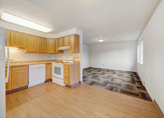 A kitchen with wooden cabinets and a white fridge.