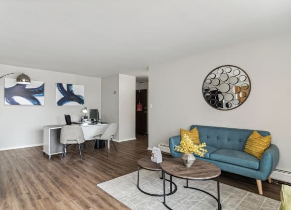 a living room and dining room with a blue couch and a table and a chair at The Reserve on Washington, Illinois, 60565