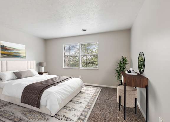 A bedroom with a large bed and a desk with a plant on it.