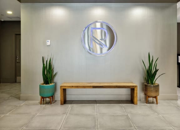 a wall with a bench and plants in a lobby at The Rowe, Grand Rapids, MI