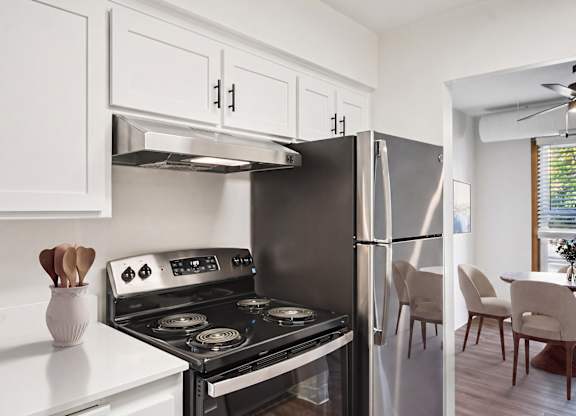 A modern kitchen with a stove, oven, and refrigerator.
