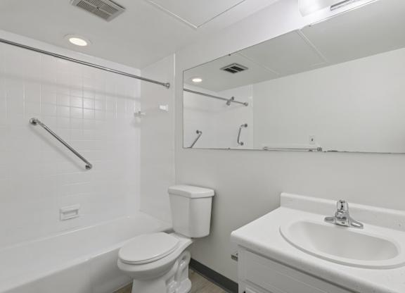 A white bathroom with a toilet, sink, and bathtub.