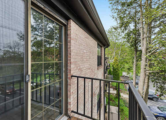 A balcony with a glass door and a black railing.