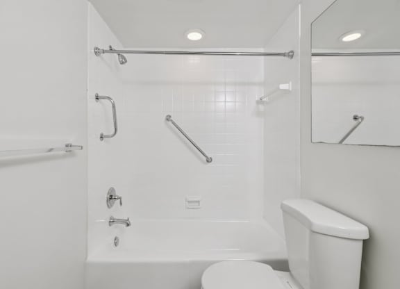 A white bathroom with a toilet, sink, and shower.