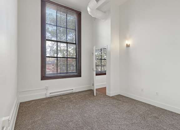 A room with a window and a chair.