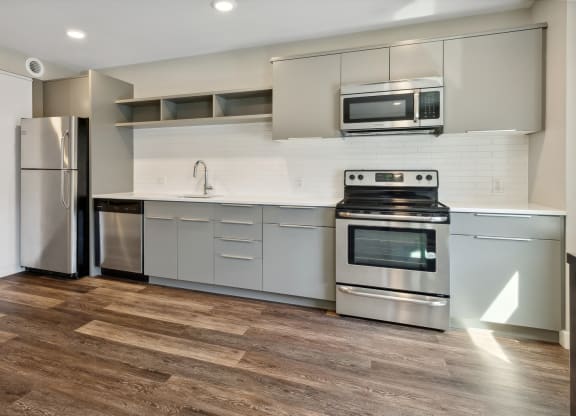 a kitchen with white cabinets and stainless steel appliances at The Rowe, Grand Rapids