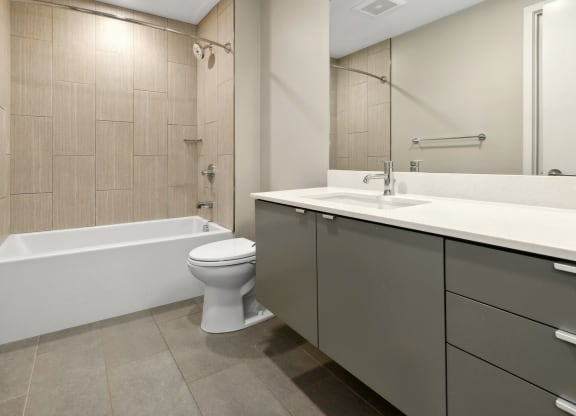 a bathroom with a toilet and a sink and a bath tub at The Rowe, Grand Rapids, 49503