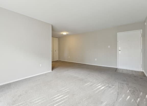 an empty living room with white walls and carpet at Briarwood Apartments, Dumfries, VA