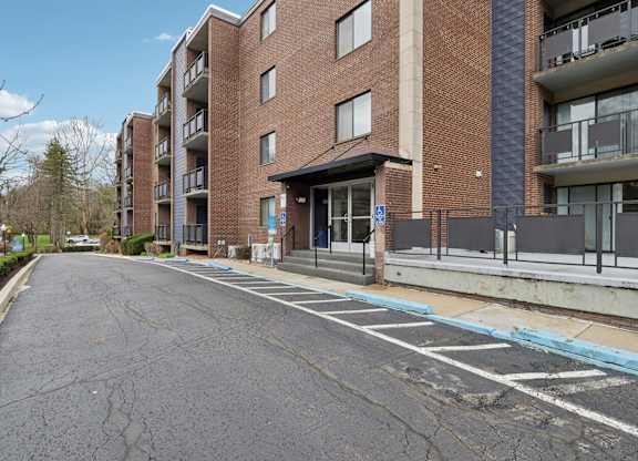 A long brick building with a parking lot in front.