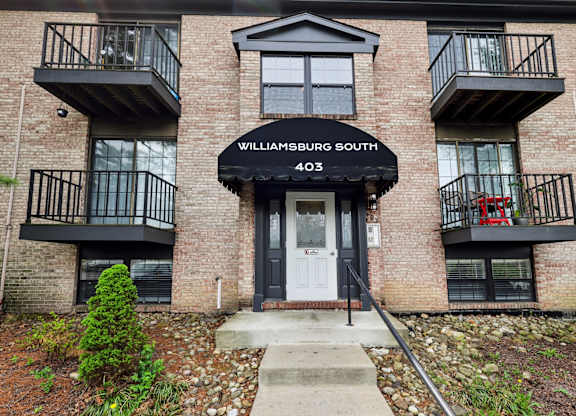 A brick building with a balcony and a door.
