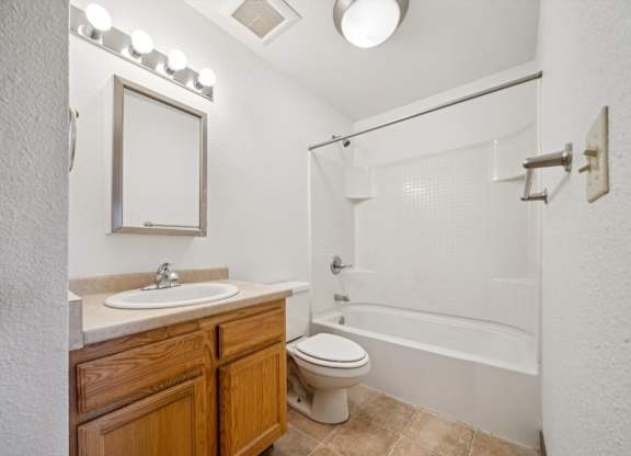 A bathroom with a toilet, sink, and bathtub.