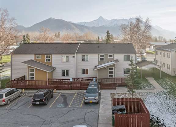 A parking lot with cars and a mountain in the background.