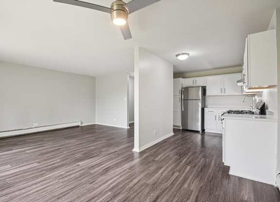 A room with a ceiling fan and wooden flooring.