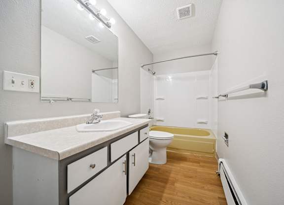 A white bathroom with a sink, toilet, and bathtub.