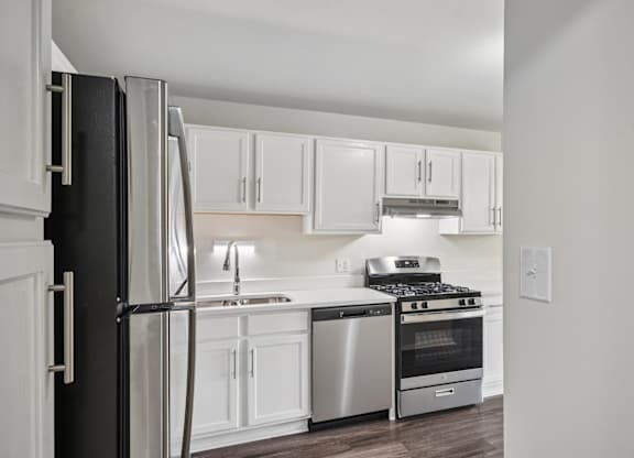 A kitchen with white cabinets and stainless steel appliances.