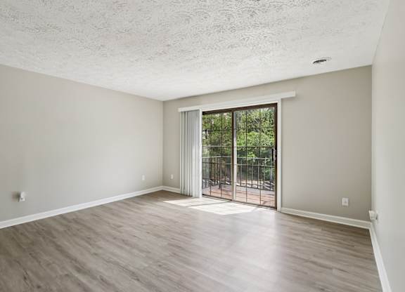 A room with a sliding glass door leading to a backyard.