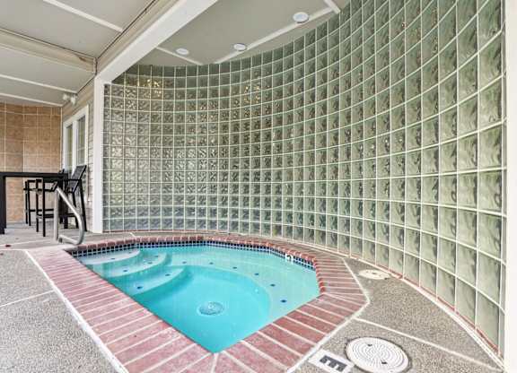A hot tub with a tiled wall.