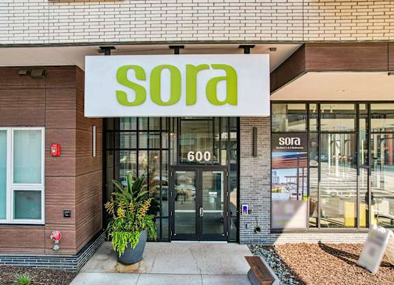 The image shows the front of a building with a sign that reads "sora 600".