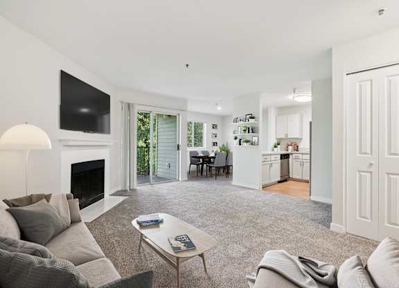 A living room with a grey couch and a fireplace.