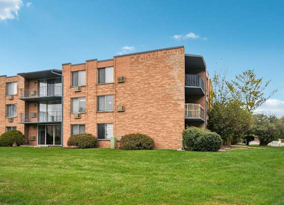 A red brick building with a balcony on the second floor.