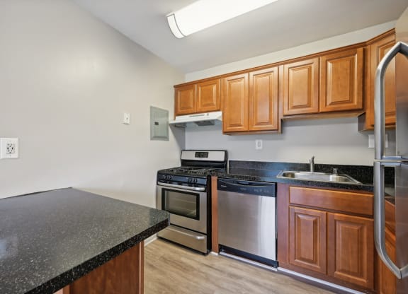 a kitchen with granite counter tops and stainless steel appliances and wooden cabinets at ReNew Odenton