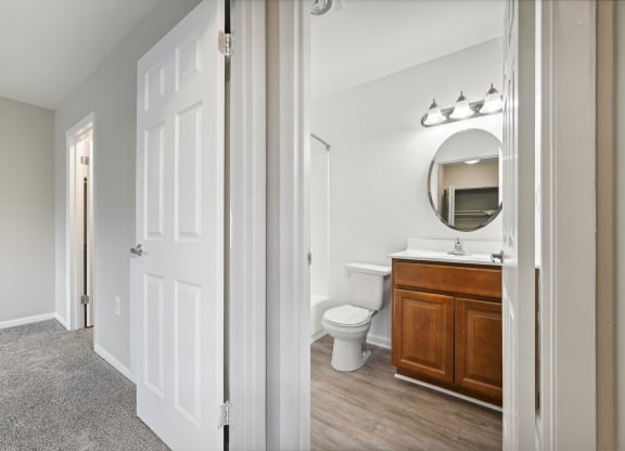 a bathroom with a toilet and a vanity with a mirror at ReNew Odenton