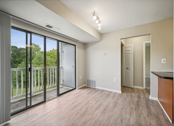 an empty living room with large windows and a balcony at ReNew Odenton
