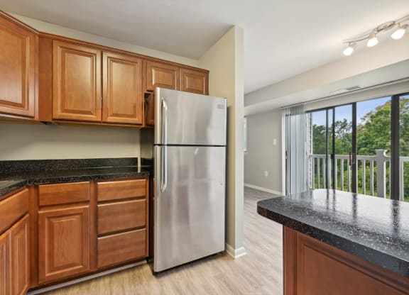a kitchen with wooden cabinets and a stainless steel refrigerator at ReNew Odenton