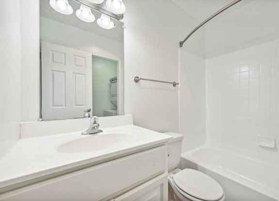 a white bathroom with a sink and a mirror at ReNew Odenton