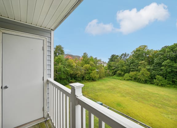 the view from the balcony of a home overlooking a grassy field and a door at ReNew Odenton